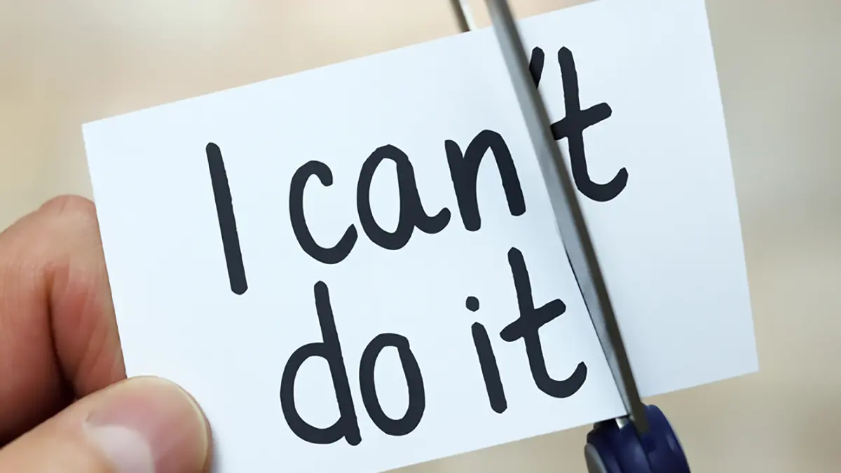 Hand die een kaartje doorknipt met de tekst 'I can't do it', waardoor 'I can do it' overblijft – symbool voor het doorbreken van belemmerende overtuigingen en het terugpakken van regie over je werkleven.