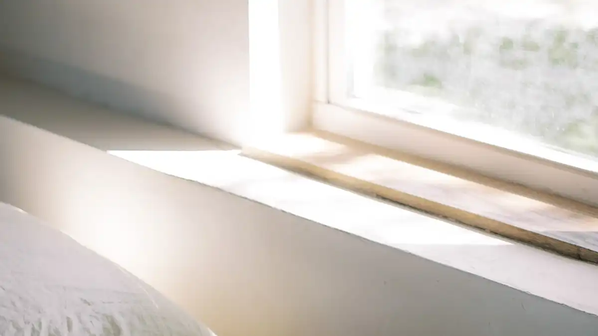 Zacht ochtendlicht op een onopgemaakt bed – symbool voor wakker worden bij jezelf