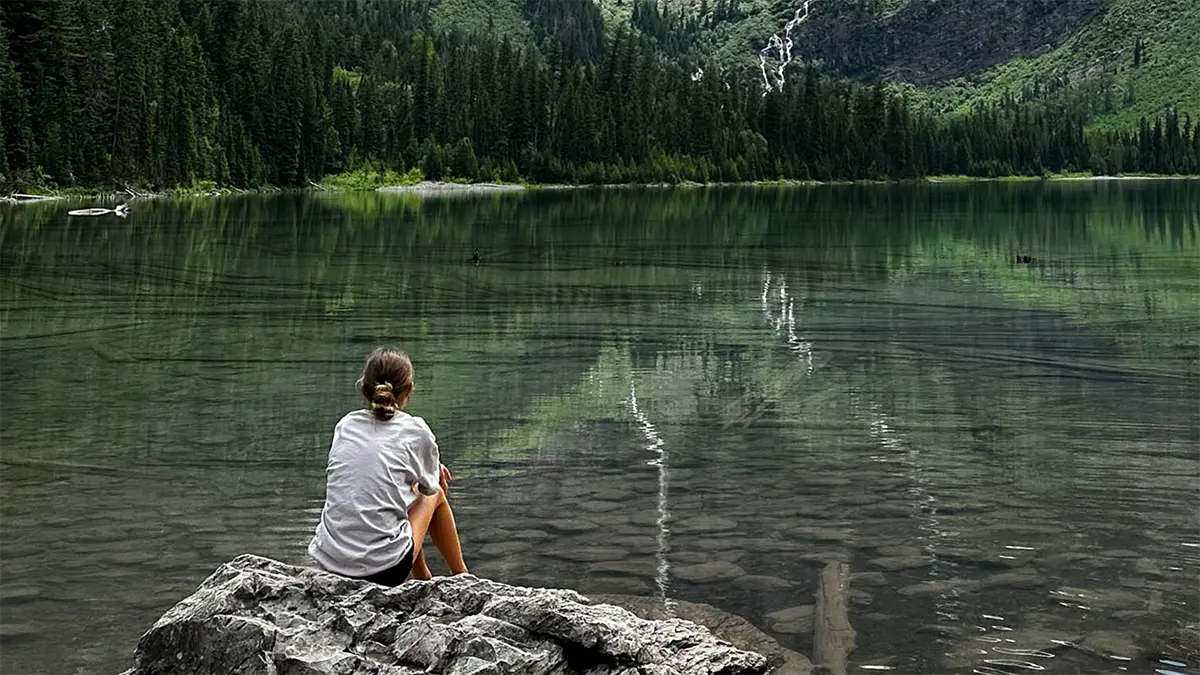 "Loopbaancoaching The New Way – vrouw aan bergmeer, moment van stilte en reflectie om thuiskomen in je werkleven te voelen."