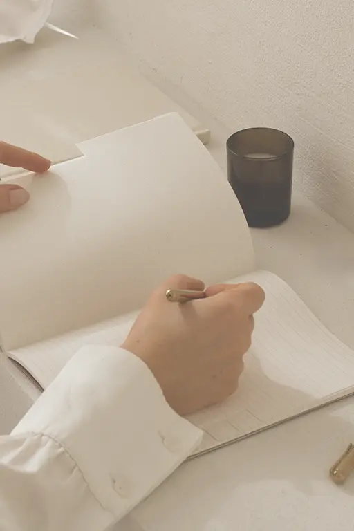 vrouw schrijft in journal over twijfel in werk Vrouw schrijft in journal over twijfel of haar werk nog bij haar past